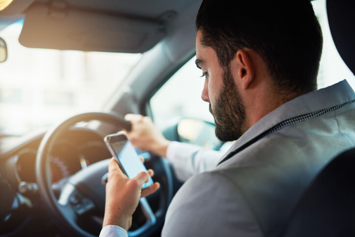 Man looking at his phone while driving