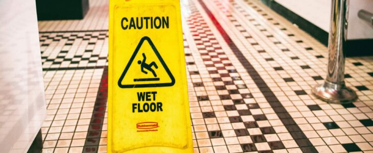 Yellow 'Caution: Wet Floor' sign on a tiled floor