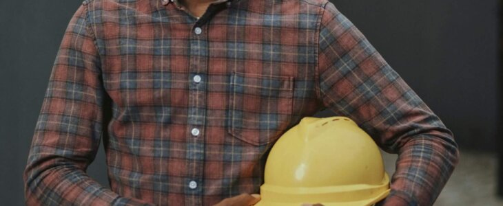 Construction worker holding a yellow hard hat